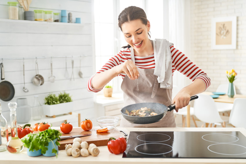 fiatal nő főz a konyhában egészséges étkezés otthon étel készítés zöldségek gomba paradicsom