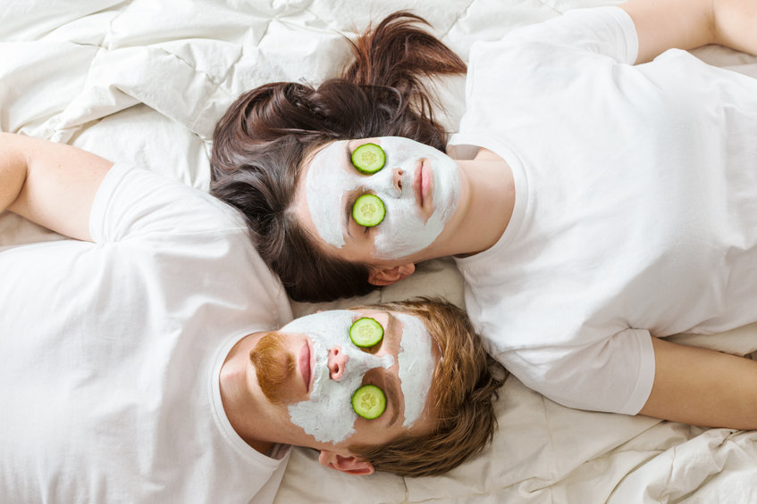 Fiatal pár ágy arcmaszk kozmetika uborka pakolás