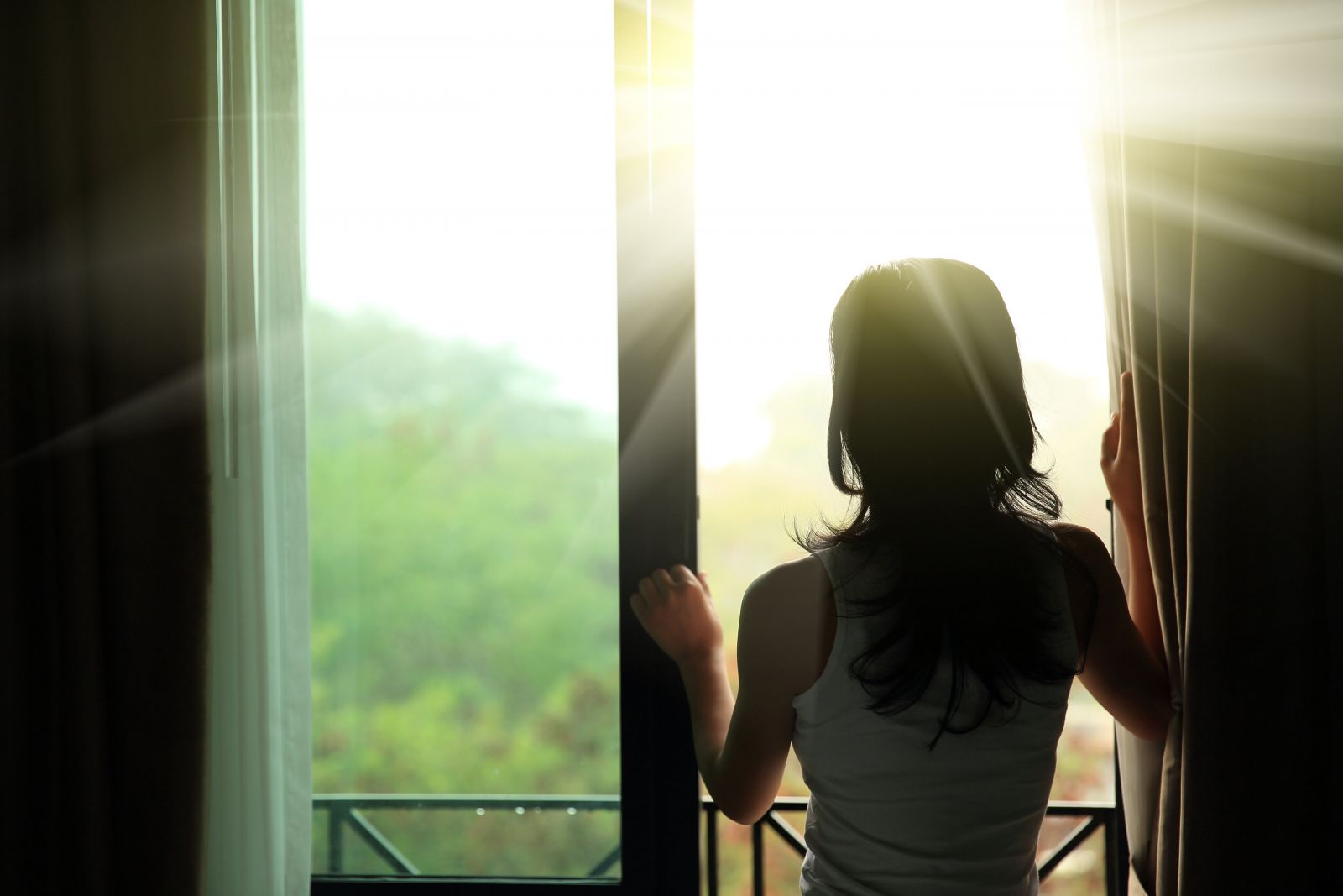 Nő kinéz az ablakon fényesség