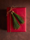 A piros csomagolás már önmagában nagyon dekoratív szín, de egy zöld dísszel karácsonyosabbá, látványosabbá tehetjük