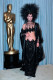 Cher mögött az aranyszobrocska bizony azt jelzi, hogy az énekesnő az Oscaron jelent meg ebben a szettben. Egy gyászos fesztiválra elmegy, de nem az Akadémia eseményére.