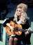 Dolly Partonba minden férfi szerelmes volt a 70-es években, ami teljesen érthető, hiszen a kor szépségideálját testesítette meg. Hatalmas tömegű haját valószerűtlenül magas kontyokba tudta tornyozni. Ha pedig gitárja is megszólalat és elkezdett énekelni, valóban lehetetlen volt nem őt nézni.
