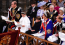 A walesi hercegi pár és három gyermekük az első sorban foglalnak helyet a koronázás alatt, míg a monarchiának búcsút intő Harry a harmadik sorban ül.
