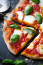 A Taste Atlas szerint a Pizza Margheritát Savoyai Margit királynőnek készítették 1889-es nápolyi látogatása során. Az élénkpiros paradicsommal, krémes fehér mozzarellával és&nbsp; bazsalikom levelekkel&nbsp;díszített étel az olasz zászló színeit hivatott ábrázolni, és a királynő állítólag nagyon el volt ragadtatva. Raffaele Esposito, a Pizzeria Brandi séfje, akinek a pitét köszönhetjük, a királynőről nevezte el. Úgy tudjuk azonban, hogy a pizza&nbsp; legalább 1866-ra nyúlik vissza, vagyis sok évvel Margherita királynő történelmet jelentő királyi látogatása előttre.
