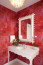 1. Használj egy tükröt a szín hangsúlyozásához!

A piros falak fokozzák a tér hangulatos eleganciáját. Egy tükör reflexiós erejének kihasználása pedig segít abban, hogy a szín átjárja a kisebb fürdőszobát, tovább fokozva az összhatást. A tükör segítségével a fény is jobban megoszlik a térben, ami további fényességet és életteli megjelenést kölcsönöz a piros színeknek, így még hangsúlyosabbá téve a fürdőszoba dizájnját.
