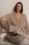 4. Kimonószerű szabás

A kötött kimonó stílusú kardigánok elegáns megjelenést kölcsönöznek viselőjüknek, miközben kényelmet biztosítanak. Ezek a darabok szélesebb ujjakkal és hosszabb szabással rendelkeznek, ami egyedi megjelenést, nem mellesleg pedig kényelmes, szellős viseletet biztosít. Ezek a kardigánok könnyen kombinálhatók a többi ruhadarabbal, így sokoldalúan alkalmazkodnak tavaszi ruhatárunkhoz.

