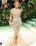 Jennifer Lopez is megmutatta formás idomait ebben az áttetsző Schiaparelli ruhában. A pillangóra emlékeztető ruhakölteményhez 2.500.000 ezüst színű gyöngyöt használtak fel, és több mint 800 óra alatt készült el.
