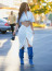 Kylie Jenner szexi, fehér outfitjét is a farmercsizma teszi még különlegesebbé. Mi ezt&nbsp;is inkább egy fesztiválra tudnánk elképzelni.

